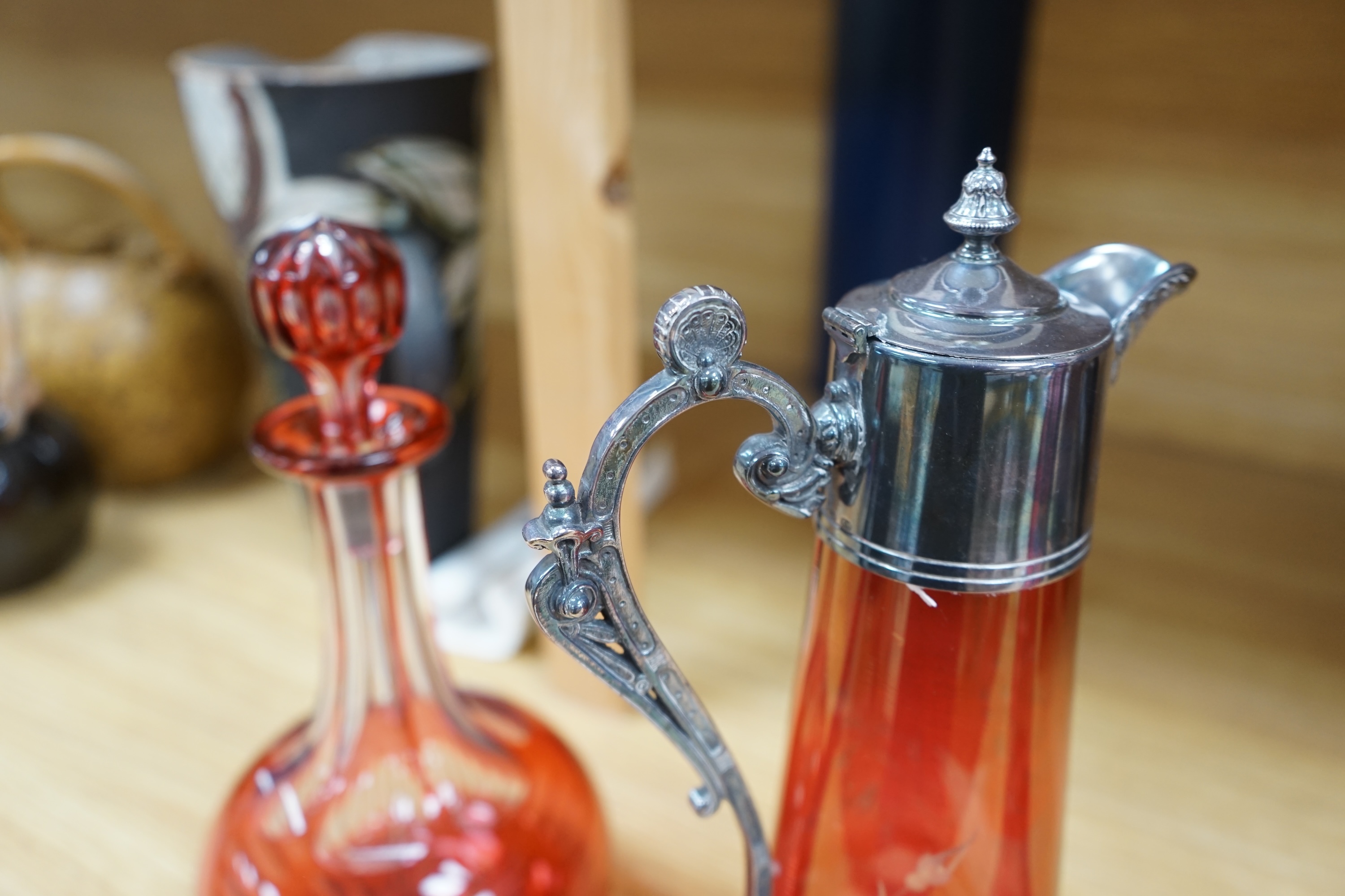 A collection of cranberry glassware comprising three decanters with stoppers and a silver plate mounted ewer, largest 41cm high. Condition - fair to good